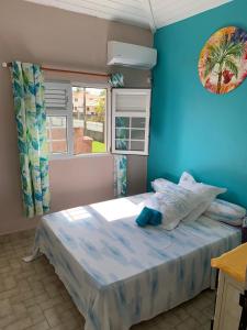 a bedroom with a bed with a blue wall at An ti kaz la in Sainte-Anne