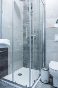 y baño con ducha y puerta de cristal. en Hotel MOREA, en Liubliana