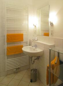 a white bathroom with a sink and a mirror at Ferienwohnung Schrammsteine in Bad Schandau