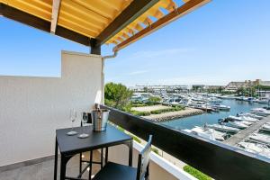 uma varanda com mesa e cadeiras e uma marina em Village Naturiste R4N - Le Candi Port Venus Panoramic View em Cap d'Agde