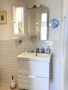 a white bathroom with a sink and a mirror at La Maisonette Antibes in Antibes