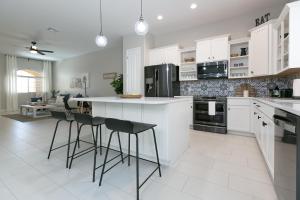 a kitchen with white cabinets and black appliances at Mesa Palms Ferro townhouse in Mesa