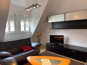 a living room with a couch and a tv at Ferienwohnung Wappenstube in Erbach