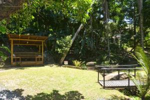 einen Garten mit einer Bank in der Mitte eines Gartens in der Unterkunft Pousada Sítio Olho D'Água in Bombinhas