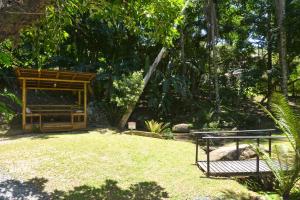 a garden with a bench in the middle of a yard at Pousada Sítio Olho D'Água in Bombinhas