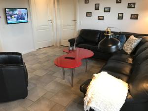 sala de estar con sofá y mesa roja en Havrevang, Luksus ferielejligheder, en Lønstrup