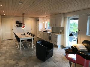 a kitchen and living room with a table and chairs at Havrevang, Luksus ferielejligheder in Lønstrup