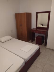 1 dormitorio con cama, tocador y espejo en White Coral, en Paralia Katerinis