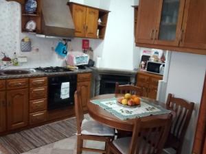 a kitchen with a table with a bowl of fruit on it at Governo's House in Melo +18 photos