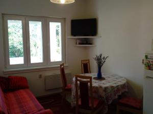 a dining room with a table with a vase on it at Detached Holiday house few steps from the beach in Veli Rat