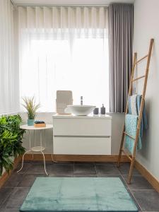 a bathroom with a sink and a mirror at Porto Je T'aime - Sweet Rooms in Vila Nova de Gaia