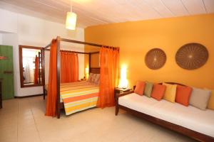 een woonkamer met 2 bedden en een spiegel bij Sobrado da Vila Hotel in Praia do Forte