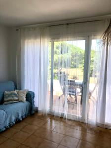 uma sala de estar com um sofá e uma porta de vidro deslizante em Espectacular apartamento con piscina en Calella de Palafrugell em Calella de Palafrugell