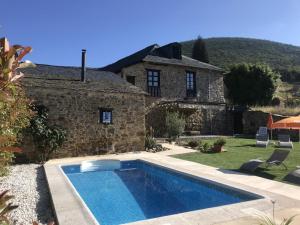 una piscina di fronte a una casa in pietra di La Casa Grande Del Valle a El Valle