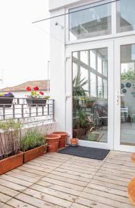 a sliding glass door on a house with potted plants at Porto Je T'aime - Sweet Rooms in Vila Nova de Gaia