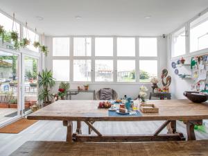 a large wooden table in a room with windows at Porto Je T'aime - Sweet Rooms in Vila Nova de Gaia