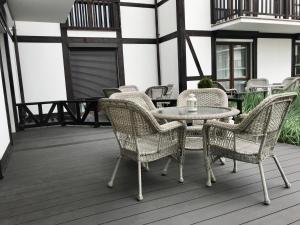 a patio with a table and chairs on a deck at Apartamenty Porto Eli in Rowy