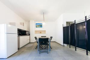 a kitchen with a table and chairs and a refrigerator at aestatisdomus in Uggiano la Chiesa