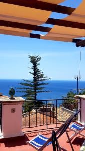 Un balcón con sillas y vistas al océano. en Villa Floresta Taormina, en Taormina