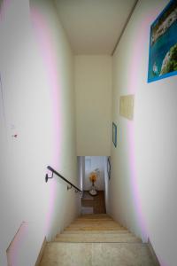 a hallway with white walls and a staircase with a painting at aestatisdomus in Uggiano la Chiesa