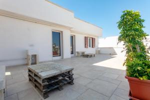 a patio with a bench on a white building at aestatisdomus in Uggiano la Chiesa