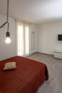 a bedroom with a large bed with a red blanket at aestatisdomus in Uggiano la Chiesa
