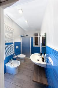a blue and white bathroom with two sinks and a toilet at aestatisdomus in Uggiano la Chiesa +49 photos