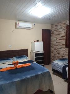 a bedroom with two beds and a air conditioner at Pousada Recanto das Fontes in Beberibe