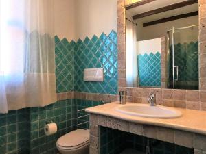 a bathroom with a sink and a toilet and a mirror at Fenile Apartments in Santa Maria Navarrese +110 photos