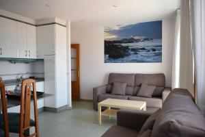 a living room with a couch and a table at Apartamentos VIDA Versus in Sanxenxo