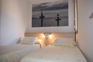 2 camas en una habitación con cruces en la pared en Apartamentos VIDA Versus, en Sanxenxo