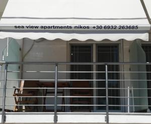 a balcony with an awning on a building at Sea View Apartments Nikos in Nea Peramos