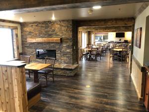 a restaurant with tables and chairs and a fireplace at Clubhouse Inn in West Yellowstone