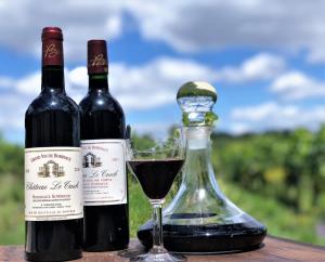 two bottles and a glass of wine on a table at Chateau le Truch in Montussan +28 photos