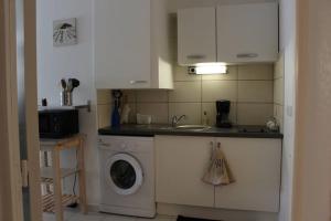 a kitchen with a washing machine and a sink at STUDIO MEUBLE 30 M2 LA LONDE LES MAURES , 900 M DES PLAGES in La Londe-les-Maures