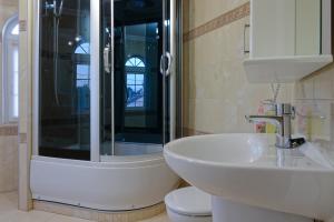 a bathroom with a shower and a sink and a toilet at White House Apartments in Odesa