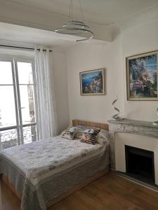 ein Schlafzimmer mit einem Bett und einem Kamin in der Unterkunft Suite Française Old Town in Antibes