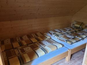 2 łóżka w pokoju z drewnianymi ścianami w obiekcie Domki Urbaczka w Istebnej w Istebnej