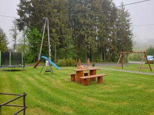 un parque con mesa de picnic y parque infantil en Domki Urbaczka w Istebnej, en Istebna