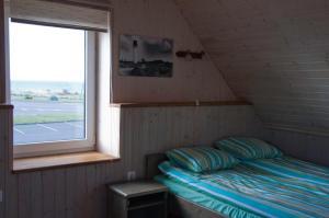 małe łóżko w pokoju z oknem w obiekcie Kaluri puhkemaja w mieście Pärna