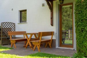 a wooden table and benches sitting on a patio at Apartments Maja by the river in Bohinj