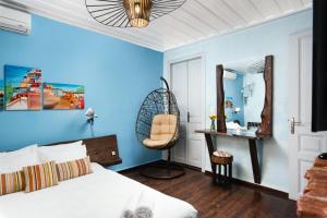 a bedroom with a bed and a chair and a mirror at Favela Living Space in Chania Town
