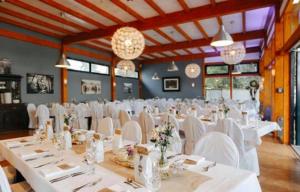 a banquet hall with white tables and white chairs at WELTRAD Am Fluß Restaurant & Quartier in Schönebeck