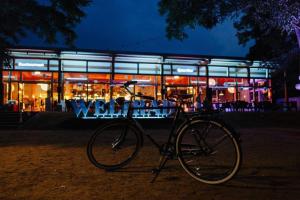 uma bicicleta estacionada em frente a um edifício à noite em WELTRAD Am Fluß Restaurant & Quartier em Schönebeck