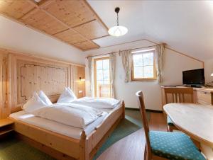 una camera da letto con un letto di legno e un tavolo di Sagritzerwirt a Grosskirchheim
