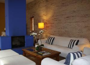 ein Wohnzimmer mit zwei weißen Sofas und einer Ziegelwand in der Unterkunft Casa el Arenal in Níjar