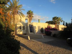 ein weißes Haus mit Palmen davor in der Unterkunft Casa el Arenal in Níjar