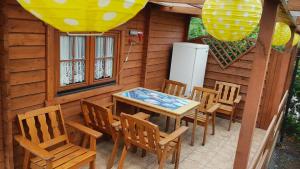 een patio met een tafel en stoelen in een hut bij Domek Wakacyjny Kacperek Drewniany in Stegna