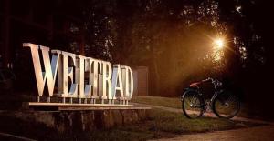 a bike parked next to a large sign at night at WELTRAD Bed&Bike Hostel am Fluss - mit eigenem Bad! in Schönebeck