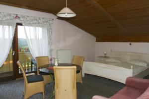 een slaapkamer met een bed en een tafel en stoelen bij Angela Steiger in Bad Griesbach